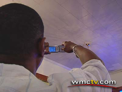 A church member frames the face of God in his cell phone